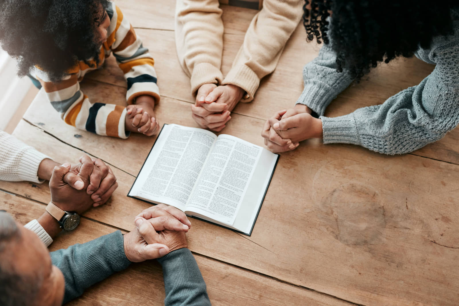 A family praying together around an open Bible